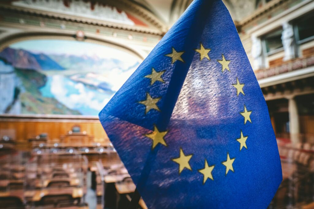 Eu fluggastrechte – Erste Reise allein (Symbolbild: Nahaufnahme der Flagge der Europäischen Union im Plenarsaal des Schweizer Nationalrats in Bern.)