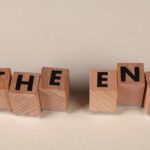 Familienversicherung ende – Erste eigene Versicherung (Symbolbild: Auf einem schlichten beigen Hintergrund sind Holzklötze so angeordnet, dass sie das Wort „The End“ buchstabieren und so einen Abschluss symbolisieren.)