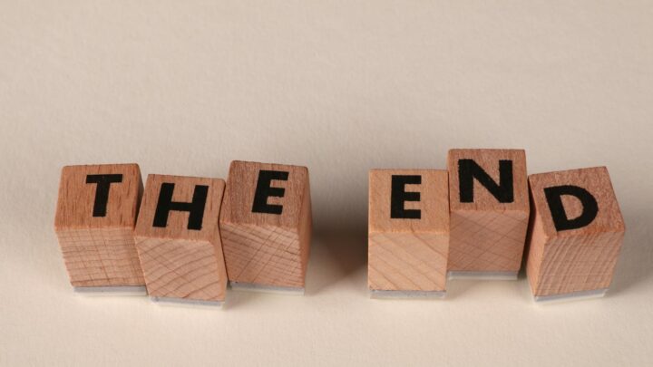 Familienversicherung ende – Erste eigene Versicherung (Symbolbild: Auf einem schlichten beigen Hintergrund sind Holzklötze so angeordnet, dass sie das Wort „The End“ buchstabieren und so einen Abschluss symbolisieren.)