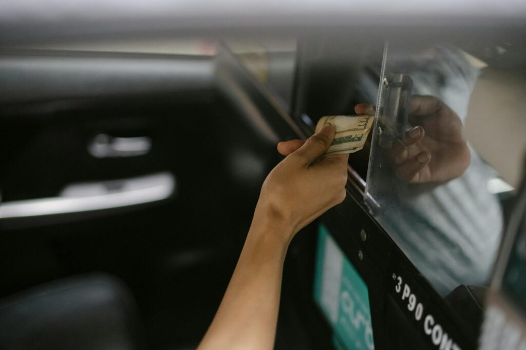 Führerschein kosten – Erstes Auto & Führerschein (Symbolbild: Innenraum Des Modernen Taxiautos, Während Passagier Für Fahrt Bezahlt)
