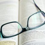Lohnabrechnung verstehen – Erster Job & Steuern (Symbolbild: Schwarz Gerahmte Brille Auf Buch)