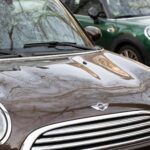 Carsharing vs eigenes auto – Erstes Auto & Führerschein (Symbolbild: Nahaufnahme von zwei Mini Cooper-Autos, die die städtische Umgebung widerspiegeln und das moderne Design betonen.)